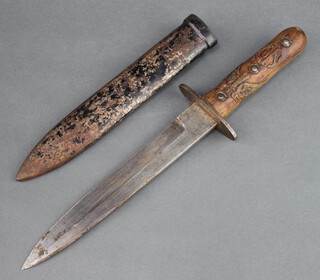 An Italian WW2 combat knife with 20cm blade, carved wooden grip and metal scabbard 