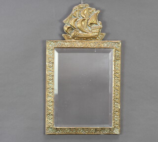 A rectangular bevelled plate wall mirror contained in an embossed brass frame surmounted by a galleon in full sail 49cm x 8cm 