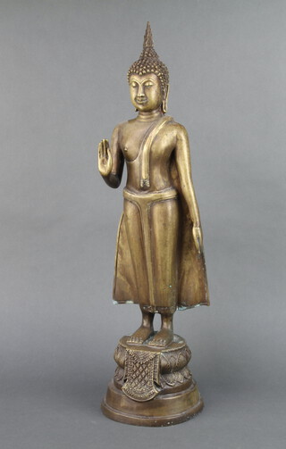 An Eastern bronze figure of a standing Buddha raised on a circular base 59cm x 16cm 