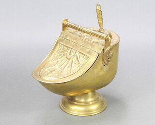 Benham, a Victorian embossed brass helmet shaped coal scuttle complete with shovel, the base with orb mark, 43cm x 50cm x 31cm 
