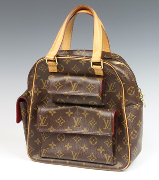 Louis Vuitton, a lady's Monogram Canvas Excentri-cite bag with 2 external pockets to the front and 1 to the side, the interior marked Louis Vuitton Paris, Made in France, 26cm h x 27cm w x 12cm, with red suede lining, complete with cloth dust bag 