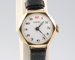 A lady's Garrard 9ct yellow gold wristwatch with red 12, contained in a 25mm case on a leather strap 