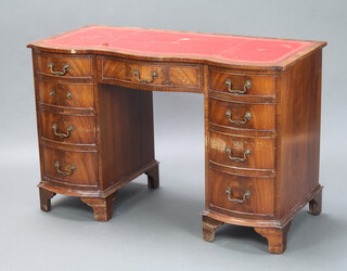 A Georgian style desk of shaped outline and red inset writing surface, fitted 1 long and 8 short drawers, raised on bracket feet 75cm h x 115cm w x 53cm d (leather scuffed to top, water damage in places, 1 handle missing) 