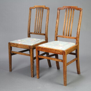 A pair of Edwardian mahogany stick and rail back dining chairs with floral upholstered drop in seats on square supports 93cm h x 44cm w x 41cm d (seat 27cm x 26cm) 