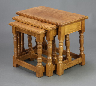 A nest of 3 light oak interfitting coffee tables raised on turned and block supports 45cm h x 59cm w x 33cm d 