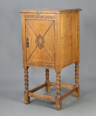 A 1930's oak cabinet enclosed by a panelled door, raised on spiral turned supports with box frame stretcher 96cm h x 45cm w x 51cm d (door locked)