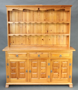 A pine dresser, the raised back with moulded cornice, shelves and 2 drawers, the base enclosed by triple panelled doors 183cm h x 160cm w x 45cm d (water stains to the top) 