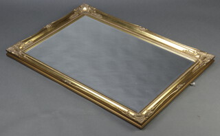 A rectangular bevelled plate wall mirror contained in a decorative gilt frame 107cm x 75cm 