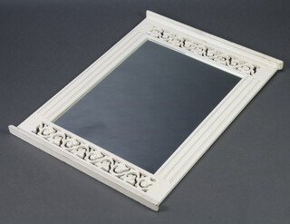 A rectangular plate mirror contained in a decorative pierced white frame 84cm x 63cm 
