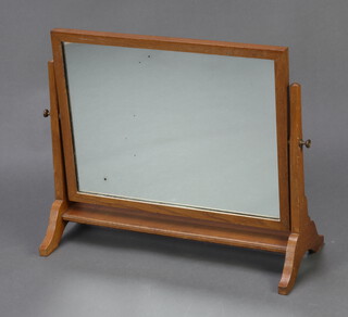 A rectangular plate dressing table mirror contained in an oak swing frame 51cm h x 60cm w x 26cm d 