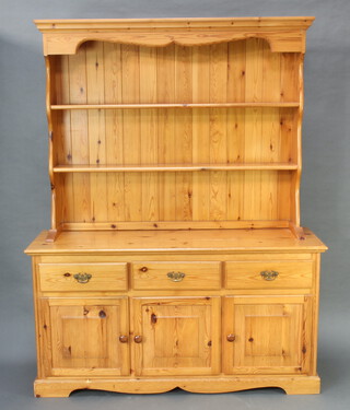 A pine dresser, the raised back fitted 2 shelves, the base with 3 drawers and triple cupboard 184cm h x 145cm w x 47cm d (contact marks in places) 
