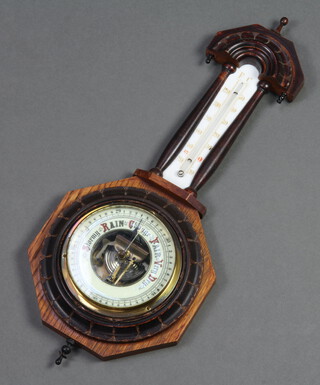 An aneroid barometer and thermometer contained in a carved oak case 