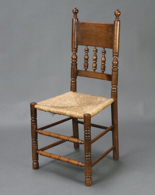 An oak bar back chair with bobbin turned decoration and woven rush seat, raised on turned supports 101cm h x 46cm w x 38cm d (seat 29cm x 32cm) 