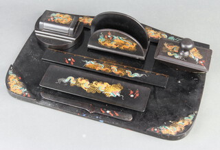 A Japanese black lacquered desk set comprising blotter, ink well, letter rack, pen tidy, ruler and paper knife, all with dragon decoration 