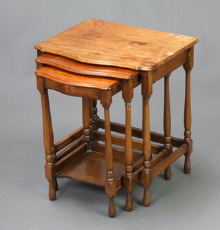 A nest of 3 1930's mahogany tables of serpentine outline, raised on turned and block supports 50cm h x 46cm w x 36cm d (ring and water marks to the top) 