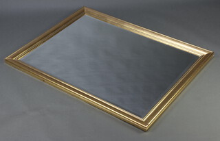 A rectangular bevelled plate wall mirror contained in a decorative gilt frame 88cm h x 113cm w