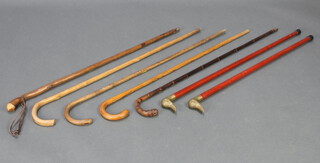 Two turned wooden walking sticks with brass ducks head handles and 5 other walking sticks 