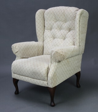 A winged armchair upholstered in white buttoned material 97cm h x 74cm w x 70cm d (seat 30cm x 38cm) 