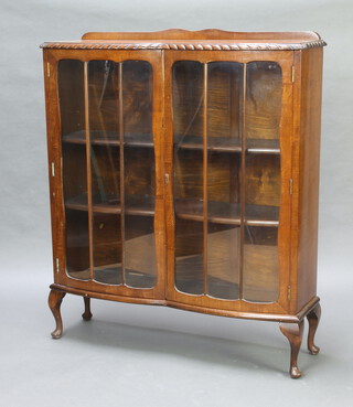 A 1930's oak display cabinet with raised back, the interior fitted adjustable shelves enclosed by astragal glazed doors 120cm h x 101cm w x 30cm d