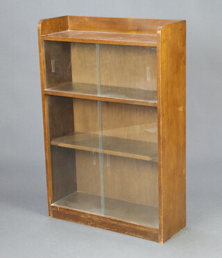 An oak display cabinet with raised doors enclosed by glazed sliding doors 92cm h x  61cm w x 22cmn d (water marks to the top)