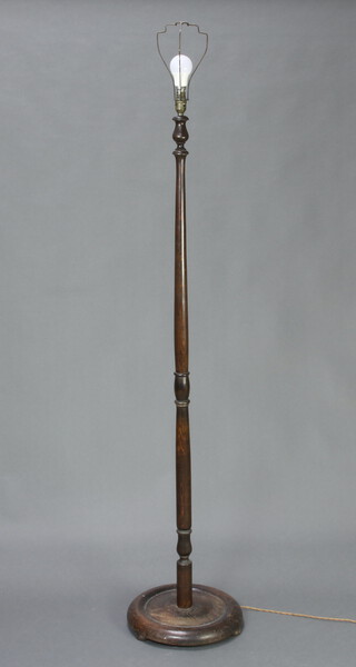 A turned beech standard lamp raised on a circular base 150cm h x 35cm diam