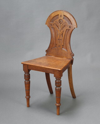 A Victorian carved light oak hall chair with solid seat and raised on turned supports 87cm h x 43cm w x 34cm d 