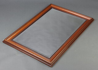 A rectangular bevelled plate mirror contained in a mahogany finished frame 105cm h x 71cm 