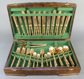 An oak canteen containing a service of bronze Thai cutlery with bamboo handles for  eight
