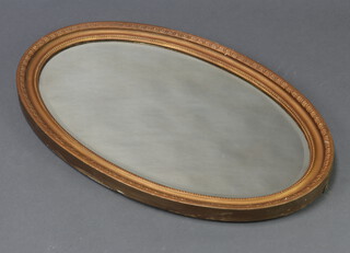 An oval bevelled plate wall mirror contained in a decorative gilt frame 53cm h x 82cm w 