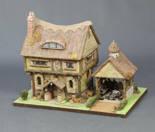 A modern of thatched cottage complete with garage 44cm h x 58cm w x 38cm d 