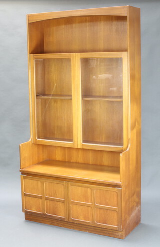 A mid Century teak wall unit fitted a recess above cupboard, fitted a shelf enclosed by a glazed panelled door above double cupboards 193cm h x 122cm w x 46cm d 