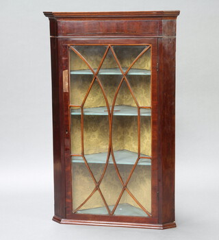 A Georgian mahogany hanging corner cabinet with moulded cornice 75cm h x 66cm w x 45cm d (section of veneer missing to the front) 