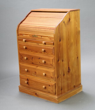 A Victorian style pine cylinder bureau, the upper section with tambour shutter enclosing a well fitted interior, above a brushing slide and 4 long drawers 109cm h x 68cm w x 51cm d 