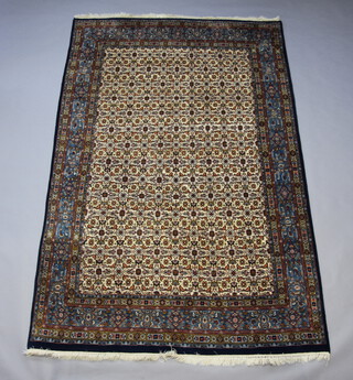 A blue and white ground Persian rug with floral design to the centre within a multi row border 301cm x 197cm 
