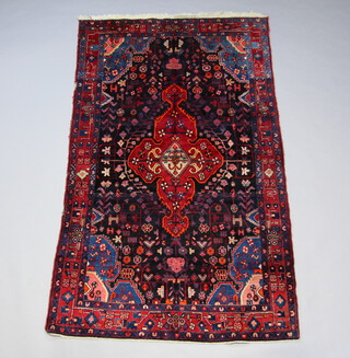 A red and blue ground Persian Kurdish rug with central medallion 259cm x 153cm 