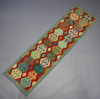 A tan, turquoise and green ground Chobi Kilim runner with overall geometric designs 292cm x 83cm 