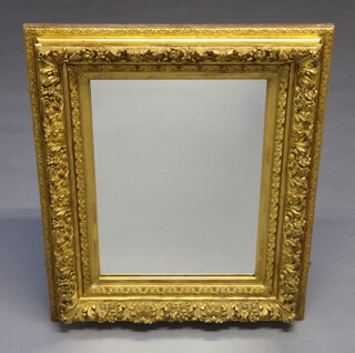 A 19th Century rectangular plate mirror contained in a decorative gilt cushion shaped frame 101cm h x 80cm w 