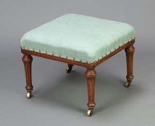 Holland & Son, a Victorian square walnut footstool upholstered in blue material, raised on turned and fluted supports ending in brass caps and casters 37cm h x 46cm w x 46cm d 