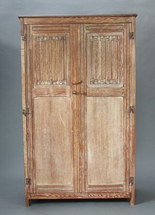 A 1930's Heals style limed oak wardrobe enclosed by panelled doors 183cm h x 110cm w x 54cm d, together with a carved oak panel end bedstead complete with irons and slats 109cm h x 141cm w x 202cm l 