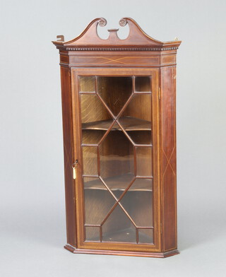 An Edwardian inlaid mahogany corner cabinet with pediment, moulded and dentil cornice, fitted shelves enclosed by an astragal glazed panelled door 104cm h x 55cm w x 35cm d  