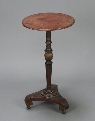 A circular Regency mahogany wine table raised on a turned column with gilt embellishment and triform base with bun feet 72cm h x 38cm diam. 