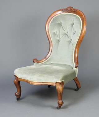 A Victorian carved walnut show frame nursing chair upholstered in blue buttoned material raised on cabriole supports 93cm h x 57cm w x 56cm d (seat 36cm x 39cm) 