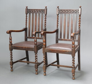 A pair of 1930's carved oak stick and rail back carver chairs with upholstered drop in seats, raised on turned supports 110cm h x 51cm w x 42cm d (seat 35cm x 30cm) 