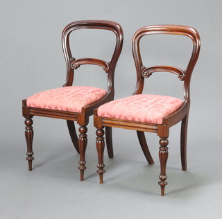 A pair of Victorian rosewood balloon back dining chairs with shaped mid rails and upholstered drop in seats, raised on turned and reeded supports 88cm h x 47cm w x 41cm d (seat 29cm x 28cm) 