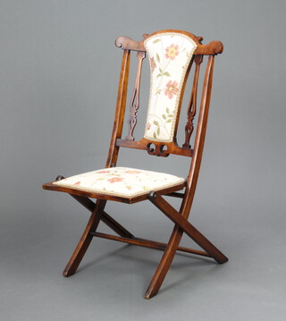 An Edwardian walnut folding campaign chair, the seat and back upholstered in floral material 94cm h x 42cm w x 43cm d (seat 29cm x 29cm) 