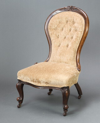 A Victorian carved walnut nursing chair upholstered in light coloured buttoned material, the seat of serpentine outline, raised on cabriole supports 95cm h x 55cm w x 48cm d (seat 34cm x 32cm) 