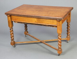 A 1930's oak metamorphic rectangular dining table incorporating a 2 seat sofa upholstered in blue material, raised on spiral turned supports with X framed stretcher, as a table 77cm h x 116cm l x 75cm w 