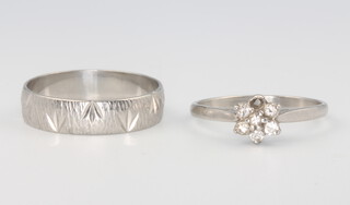 A platinum wedding band size S, 4.5 grams, together with a platinum diamond daisy ring (1 stone missing), 3 grams gross 