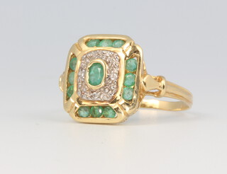 A yellow metal emerald and diamond dress ring, stamped 750, size N 1/2, 3.5 grams