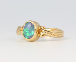 An 18ct yellow gold oval black opal ring, size L 1/2, 3.6 grams 